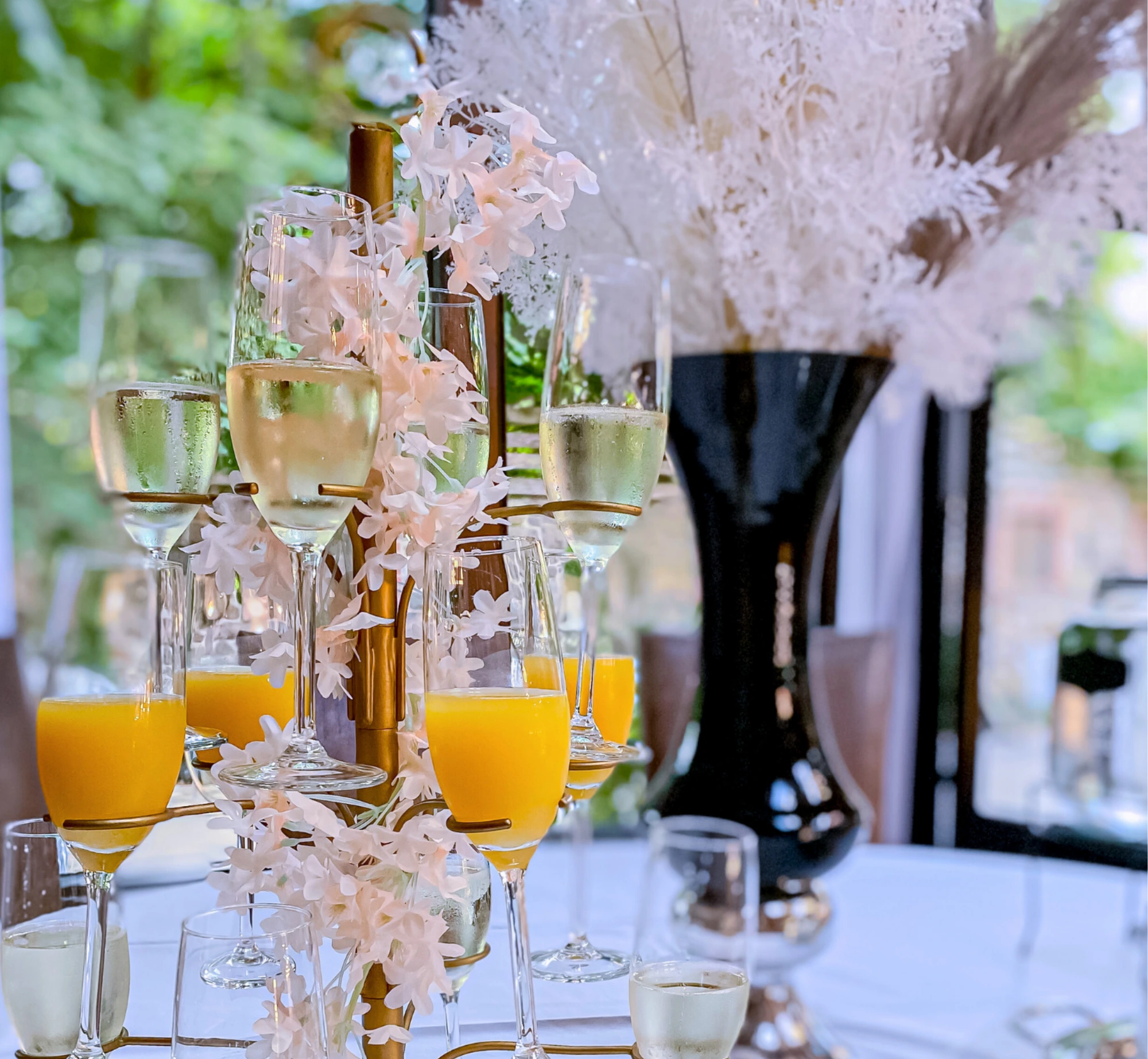Getränkehalter mit gefüllten Gläsern mit Orangensaft und Sekt