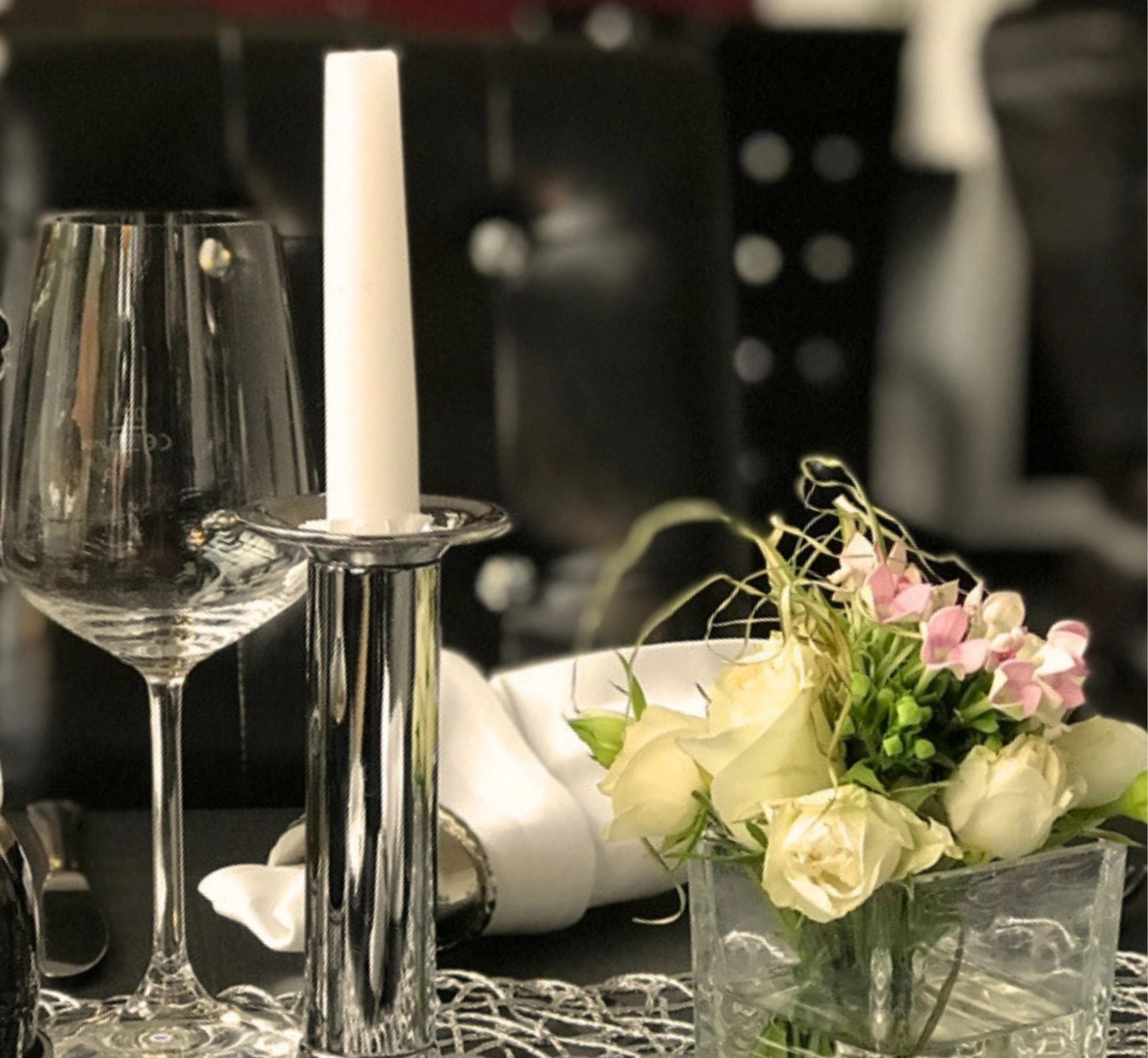Weiße Kerze mit Blumenstrauß